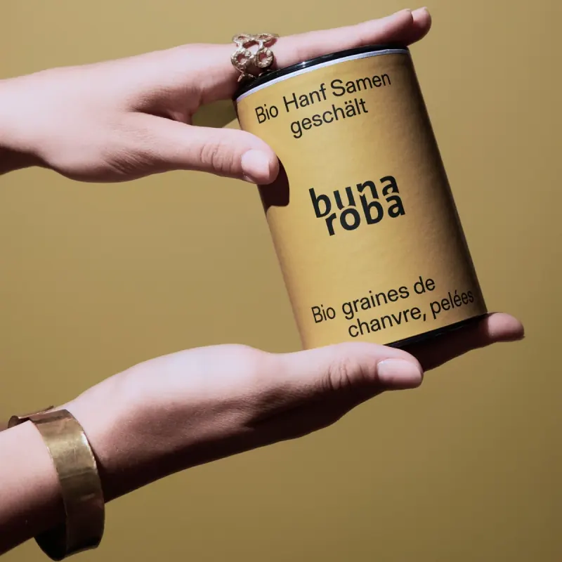 Hände halten eine Dose bunaroba Hanfsamen